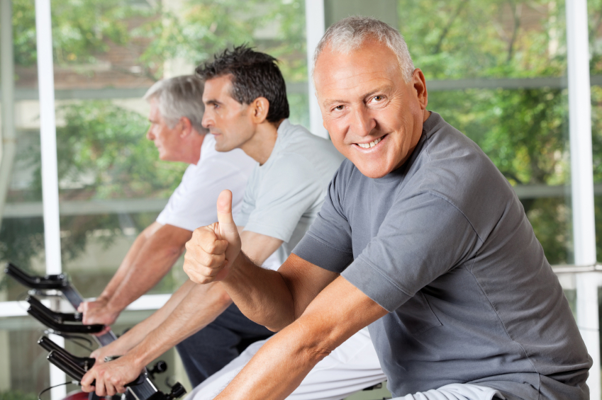 Senior man on bike holding thumbs up